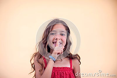 Little girl shows shhh sign and smile. Children and emotion concept Stock Photo