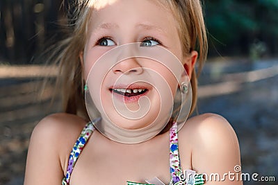 A little girl shows a wobbly baby tooth in her mouth Stock Photo