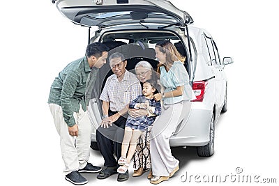 Little girl sits with her big family in car trunk Stock Photo