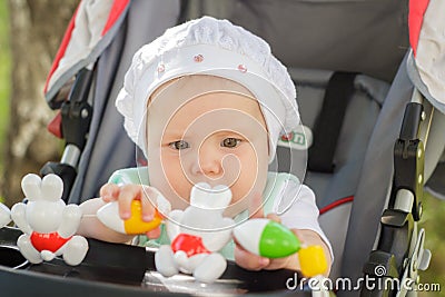 Little girl sitting in a baby carriage Stock Photo