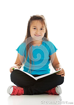 Little girl sitting cross legged and learning Stock Photo