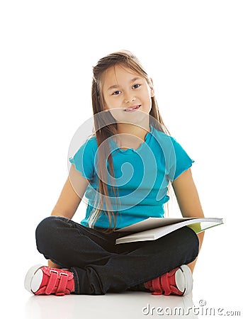 Little girl sitting cross legged and learning Stock Photo