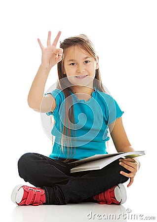 Little girl sitting cross legged and learning Stock Photo