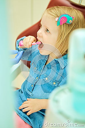 Little girl sitting in the dentists office Stock Photo