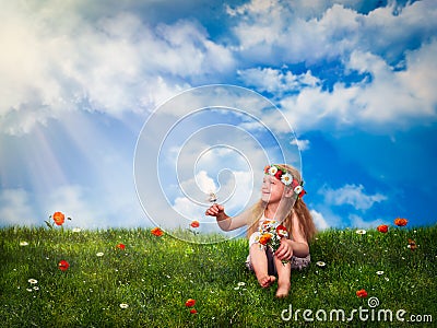 Little girl sitting on green grass and squinting in the sun. The child keeps on hand a butterfly and a bouquet of flowers. Stock Photo