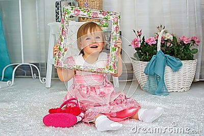 The little girl is sitting and smiling Stock Photo