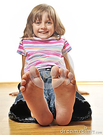 Little girl sitting on a wooden floor Stock Photo