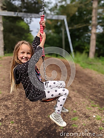 Little girl sliding down a zip wire Stock Photo