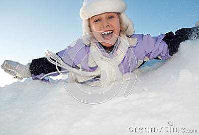 Little girl sliding in the snow Stock Photo