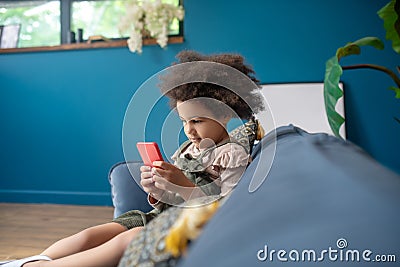 Little girl with smartphone at home in room Stock Photo