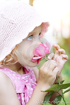 Little girl smelling pink rose Stock Photo