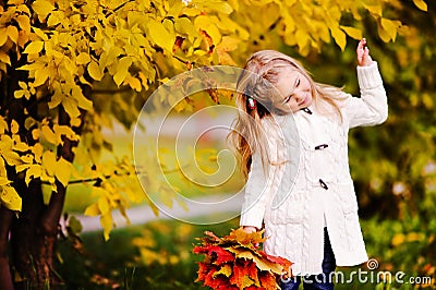 Little girl smiling at autumn park Stock Photo