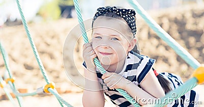 Little girl smiling, hanging on a rope Stock Photo