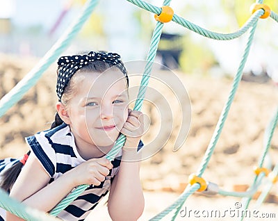 Little girl smiling, hanging on a rope Stock Photo