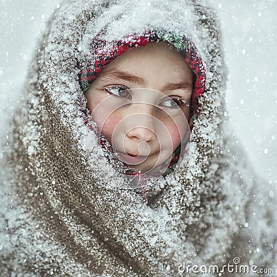 A little girl in a snow-covered shawl Stock Photo