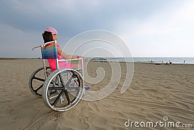 Little girl on the special wheelchair with big wheels in alumini Stock Photo