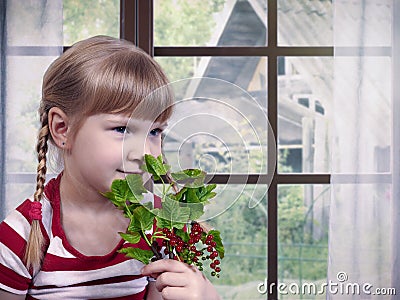 Little girl with sprigs of red currants near the window Stock Photo