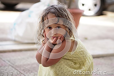 Little girl squats Stock Photo