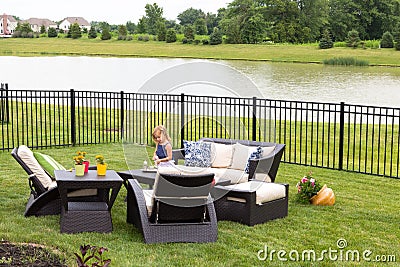 Little girl standing amongst garden furniture Stock Photo