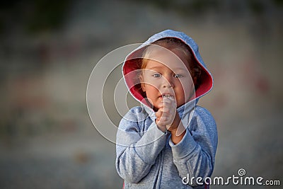 Little girl is standing with her hands clasped and begging to fulfill her desire Stock Photo