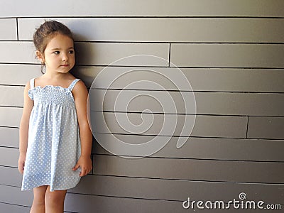 Little girl standing over modern brick Stock Photo