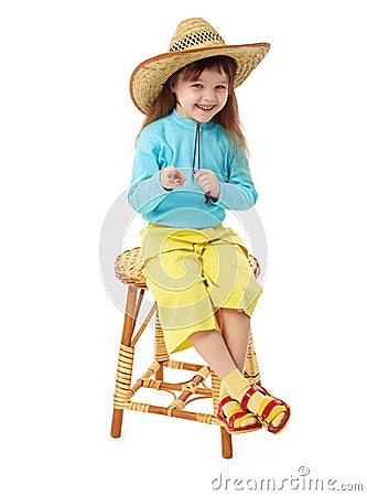Little girl in straw hat sitting on wooden chair Stock Photo