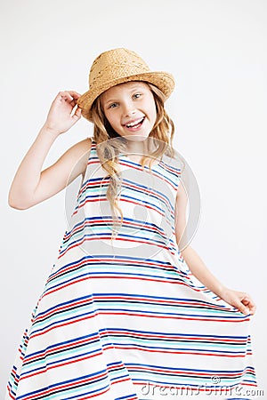 little girl with straw hat and striped dress against a white background. Happy kids Stock Photo