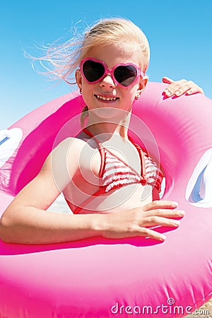 little girl in swimsuit playing with a lifebuoy on the sea Stock Photo