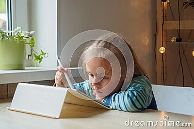 Little girl with tablet and stylus learning drawing online Stock Photo