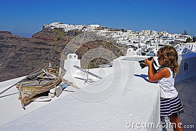 little girl takes pictures of beautiful views of Santorini Stock Photo