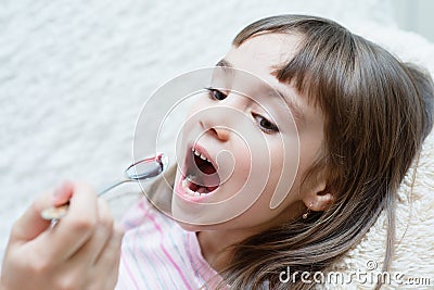 Little girl taking medicine with spoon Stock Photo