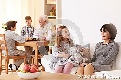 Little girl talking with grandmother in living room Stock Photo