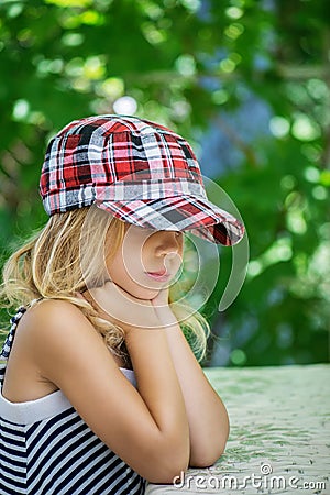 Little girl talking in plaid cap Stock Photo