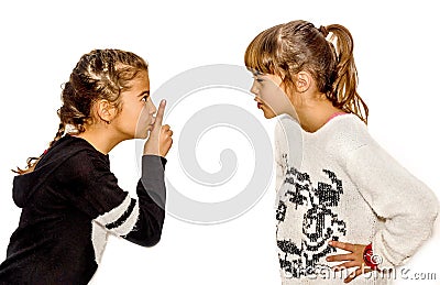 Little girl telling her sister to shut up with her finger on the Stock Photo