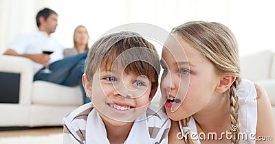 Little girl telling a secret to her brother Stock Photo