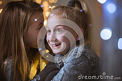 Girl telling secret to sister Stock Photo