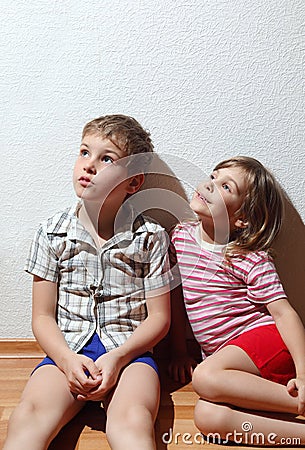 Little girl and thoughtful boy sitting Stock Photo