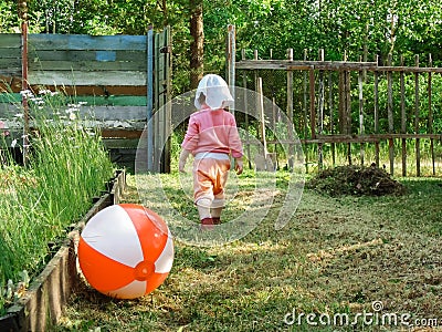 The little girl threw all the games and goes into the open gate on the road Stock Photo
