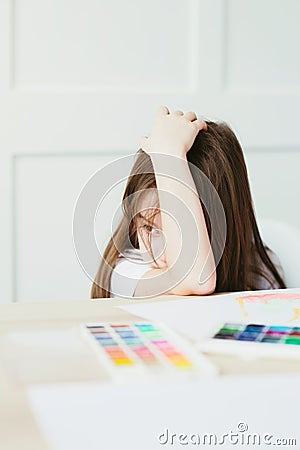 Little girl tired to draw and lay down to rest. Girl is naughty and does not want to draw. Stock Photo