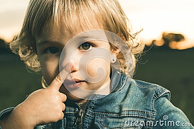Little girl touching her nose with a finger Stock Photo