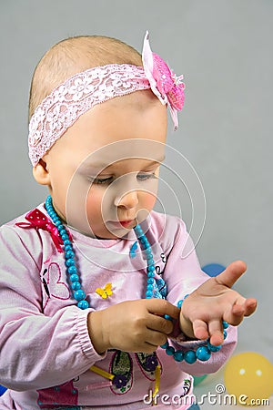 The little girl tries on a beads Stock Photo