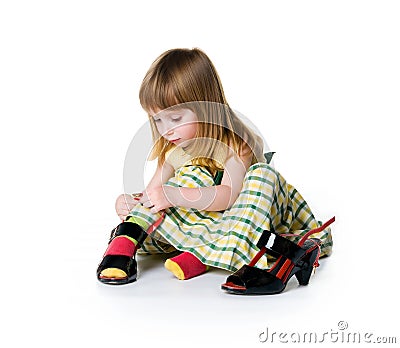 Little girl try on big shoes Stock Photo