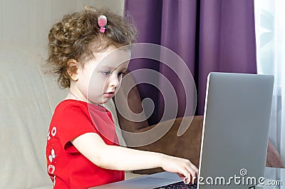 Little girl uses laptop. copy space. child and computer games, addiction. Stock Photo