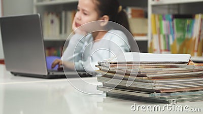 Little girl using laptop at school studying doing homework Stock Photo