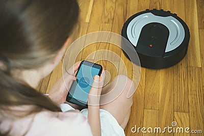 Little girl and robotic vacuum cleaner. Stock Photo