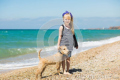 Little girl walking on the beach with a puppy terrier Stock Photo