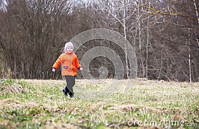 Little girl walks outdoors. Happy child in countryside. Early spring. Stock Photo