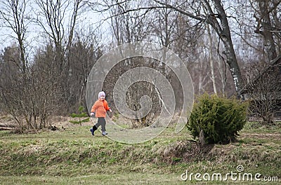 Little girl walks outdoors. Happy child in countryside. Early spring. Stock Photo