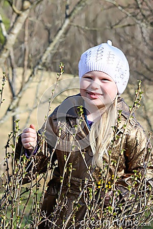 Little girl walks outdoors. Happy child in countryside. Early spring. Stock Photo