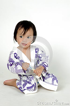 little girl wearing bathing suit holding a toothbr Stock Photo